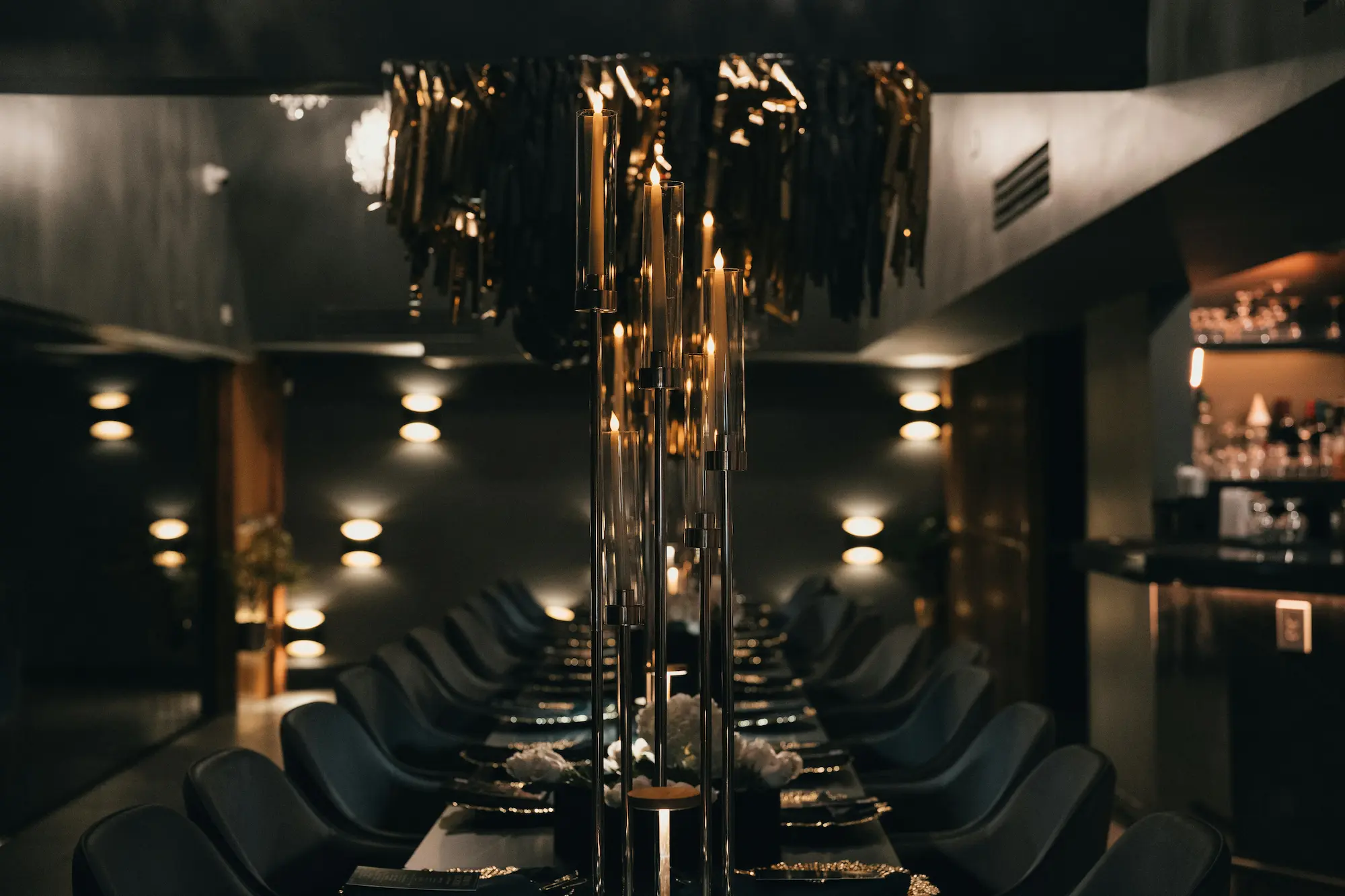 Elegant gedeckte Tafel in dunklem Ambiente mit Kerzenleuchtern